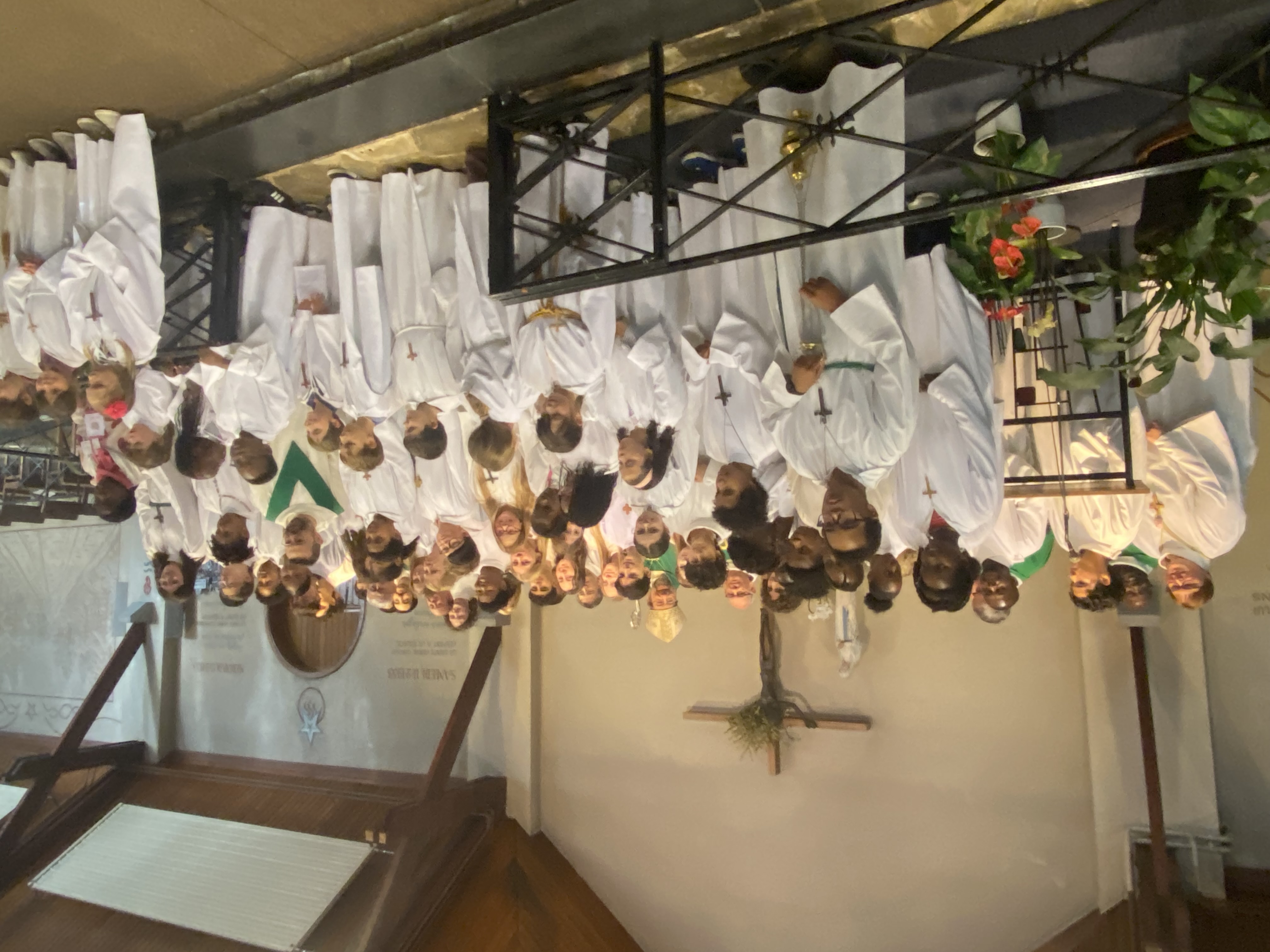 Photo de groupe au sanctuaire de Banneux : des dizaines d'acolytes en aube blanche, enfants et jeunes souriants, entourent Mgr Jean-Pierre Delville, en mitre, ainsi que des prêtres et un diacre