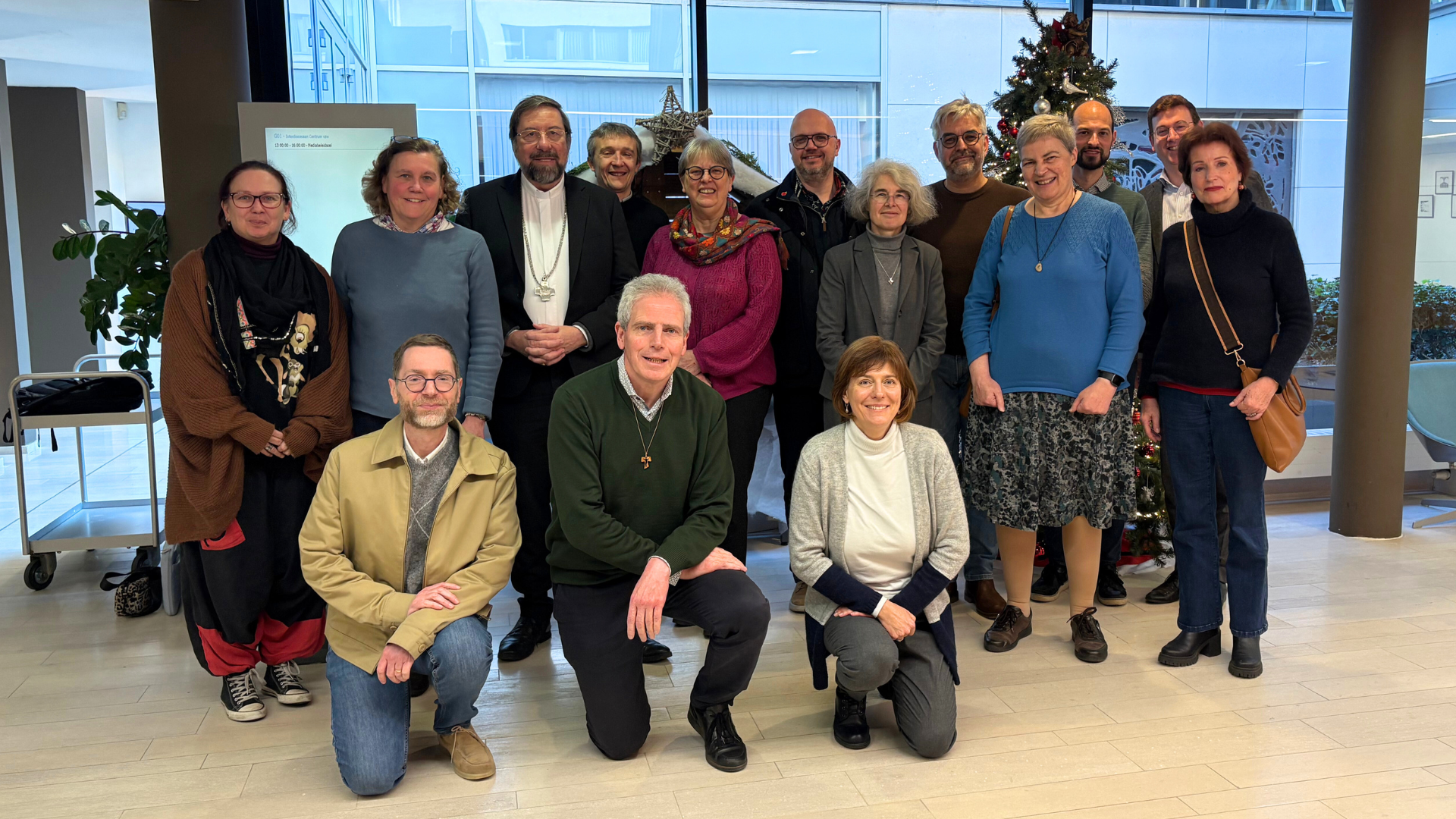 Photo de groupe de l'équipe synodale nationale, dont Delphine Mirgaux et Mgr Jean-Pierre Delville, une quinzaine de personnes debout et agenouillées